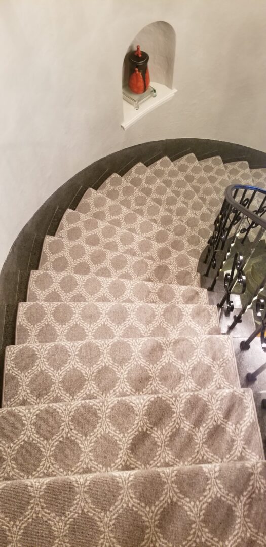 A staircase with a metal railing and beige carpet.