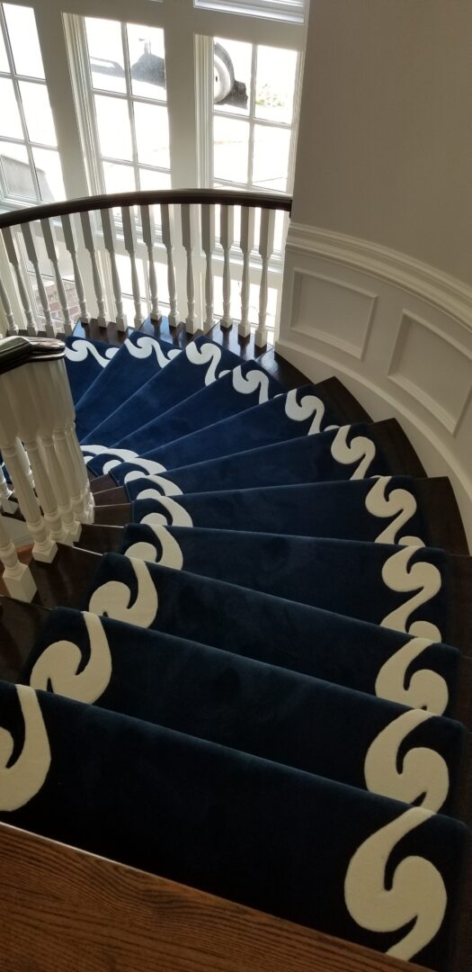 A staircase with blue and white carpet on the bottom.