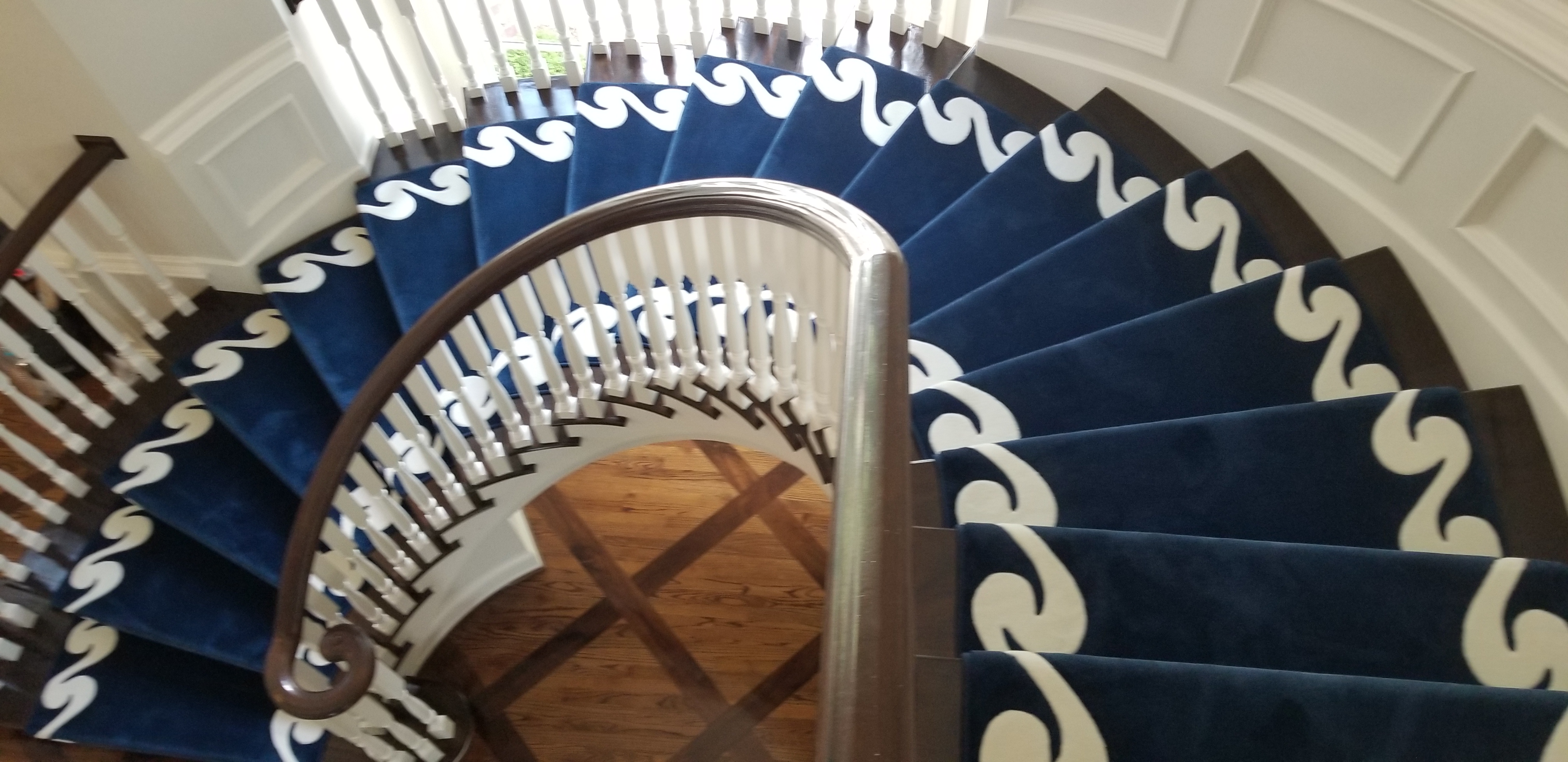 A spiral staircase with blue and white carpet.