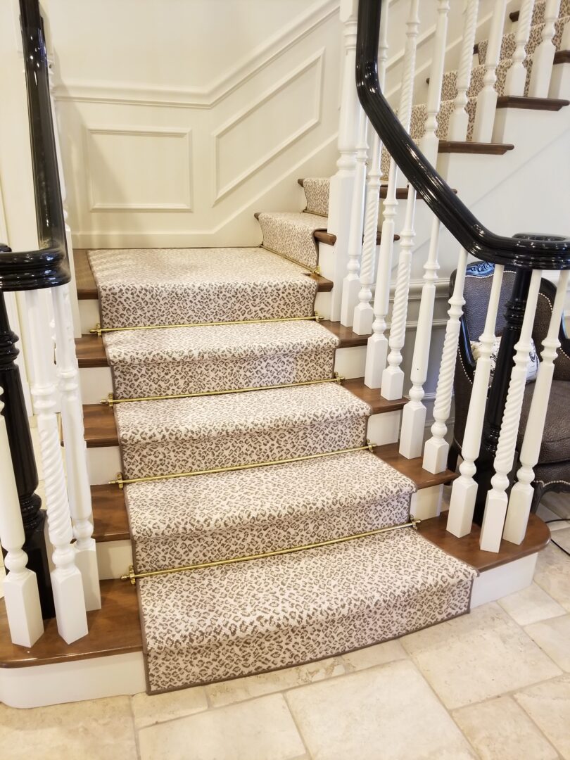 A staircase with animal print carpet and white railing.