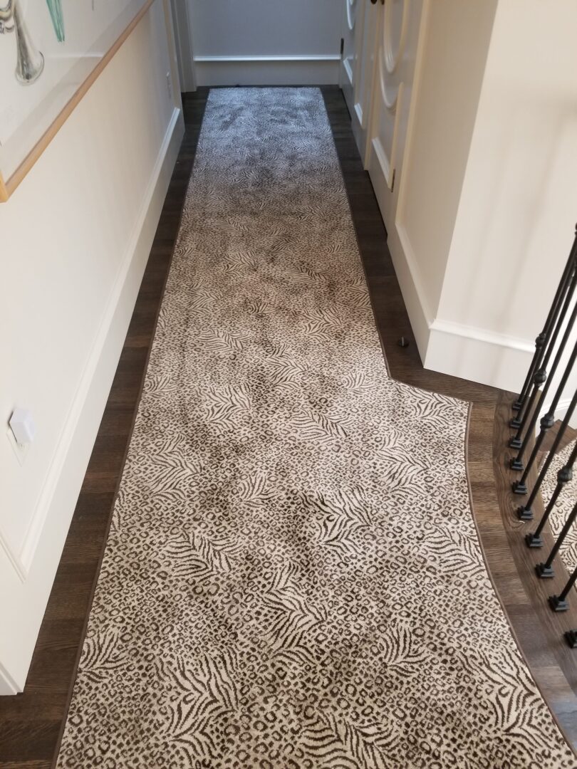 A hallway with stairs and carpet on the floor.