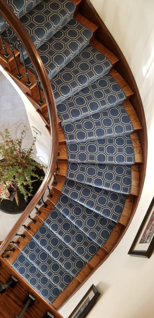 A spiral staircase with blue and white carpet.