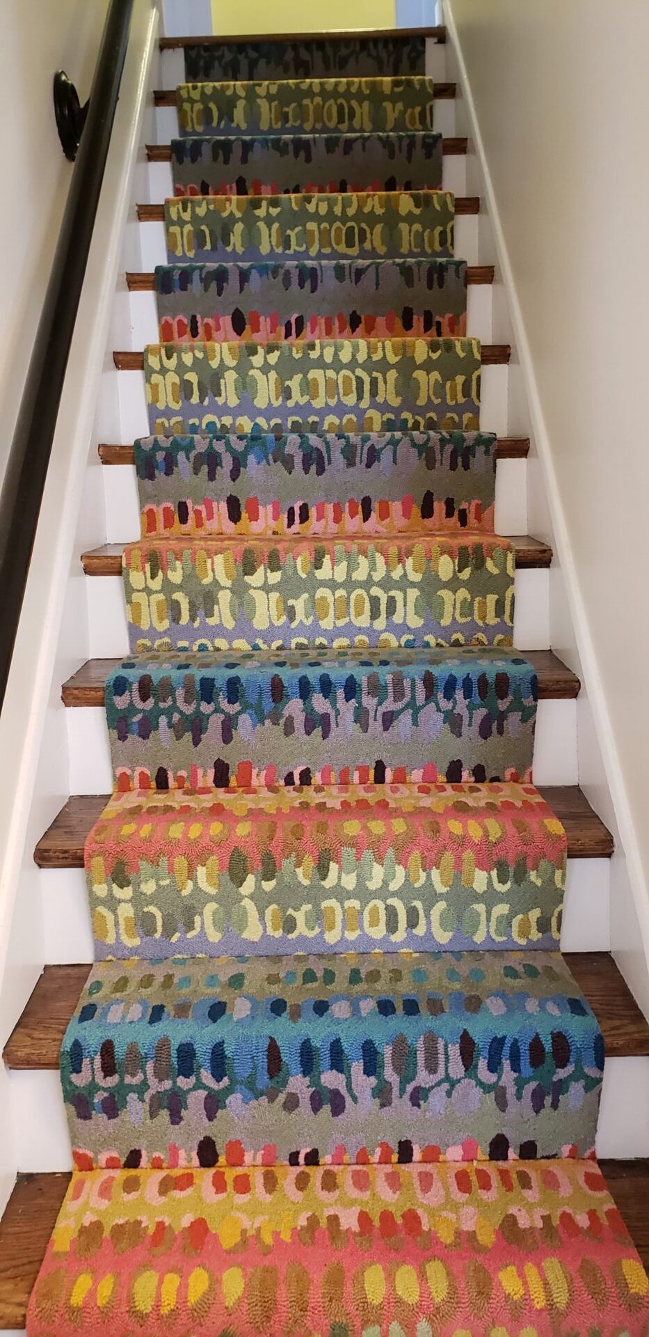 A colorful stair runner is painted with many colors.
