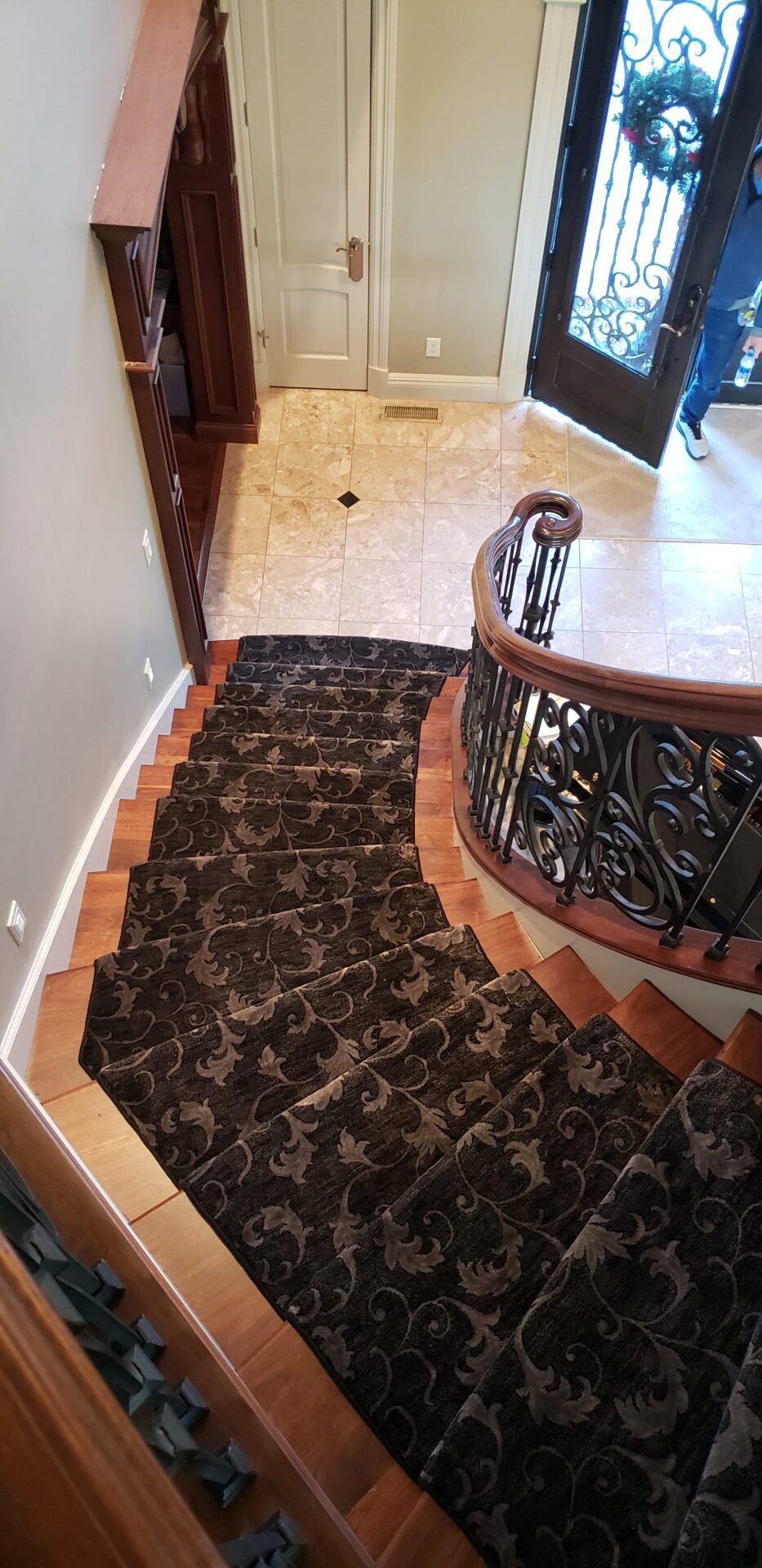 A staircase with a wrought iron railing and carpet.