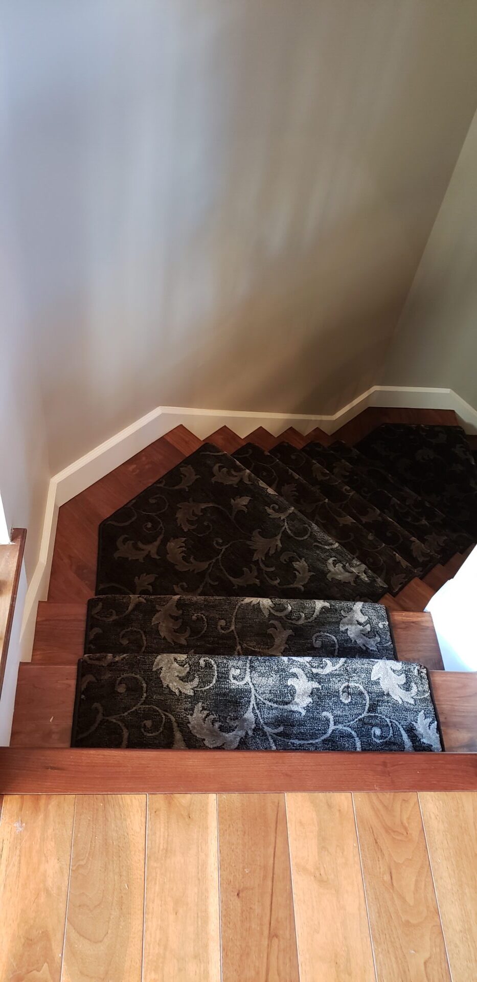 A staircase with black and white carpet on the bottom of each step.