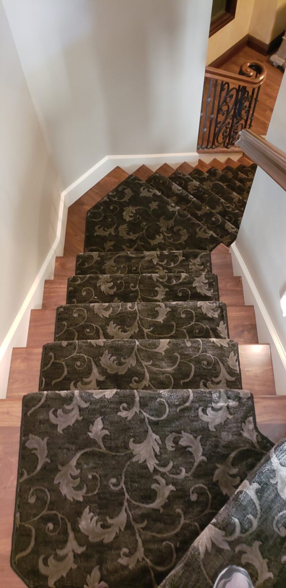 A staircase with brown and black carpet on the bottom of each step.