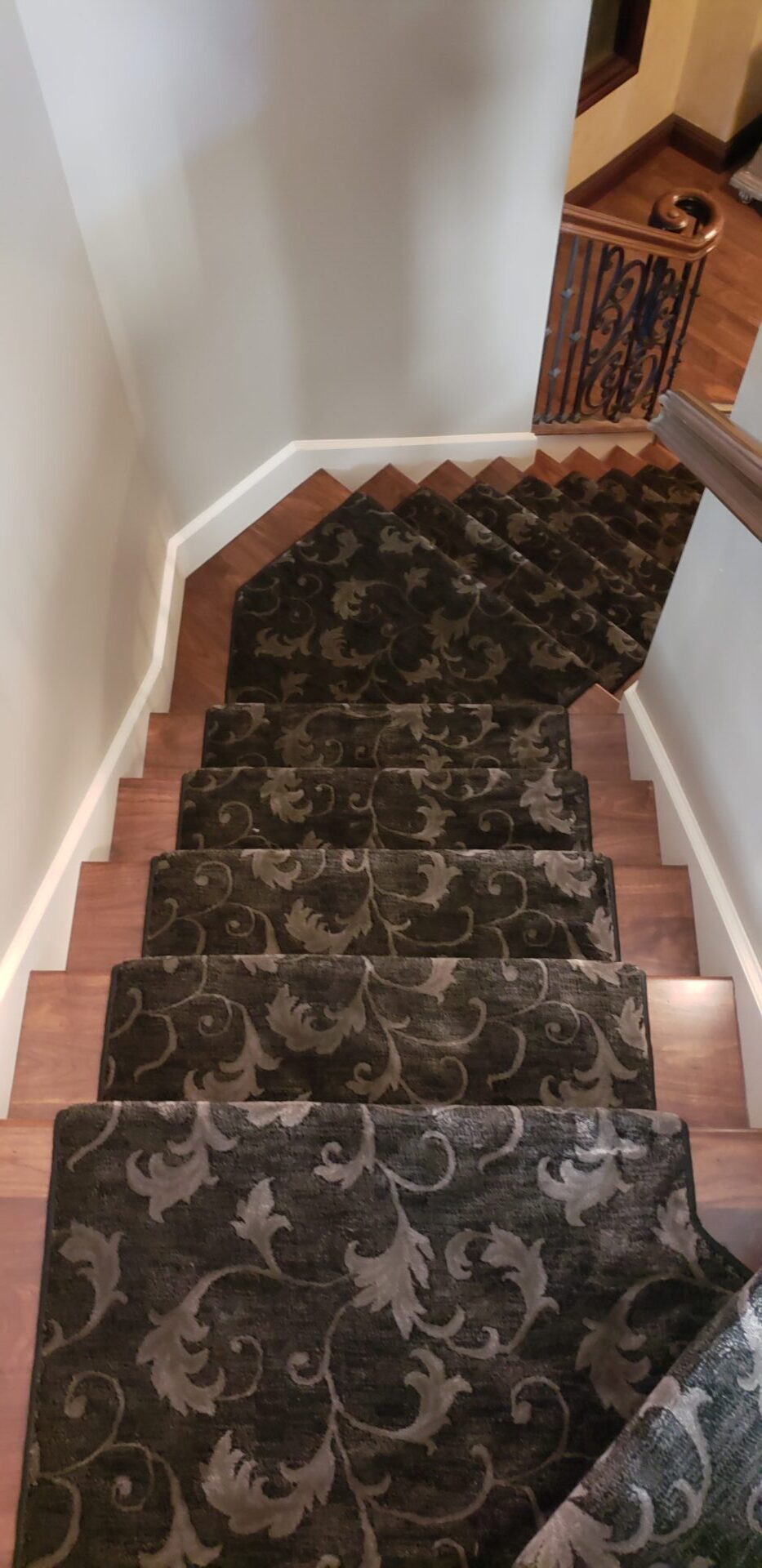 A staircase with brown and black carpet on the bottom.