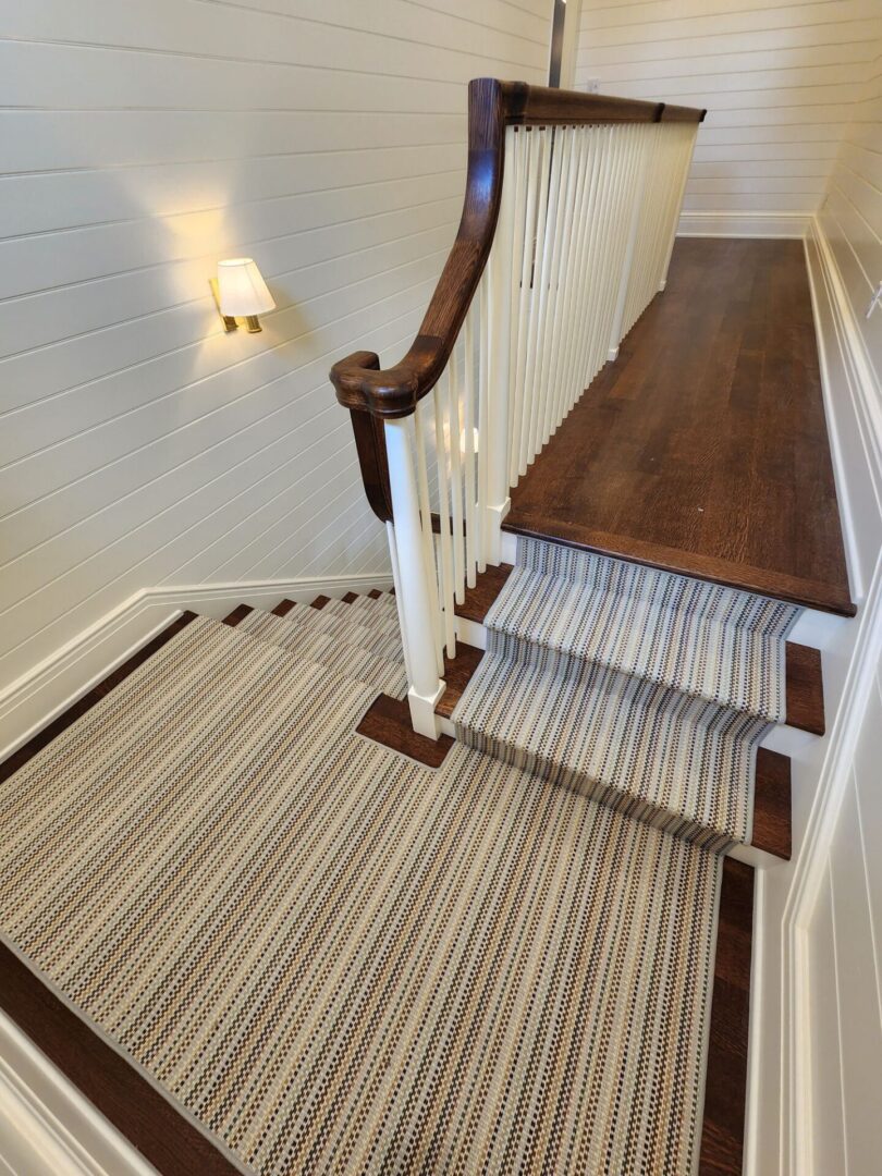 A staircase with wood treads and carpet on the bottom.