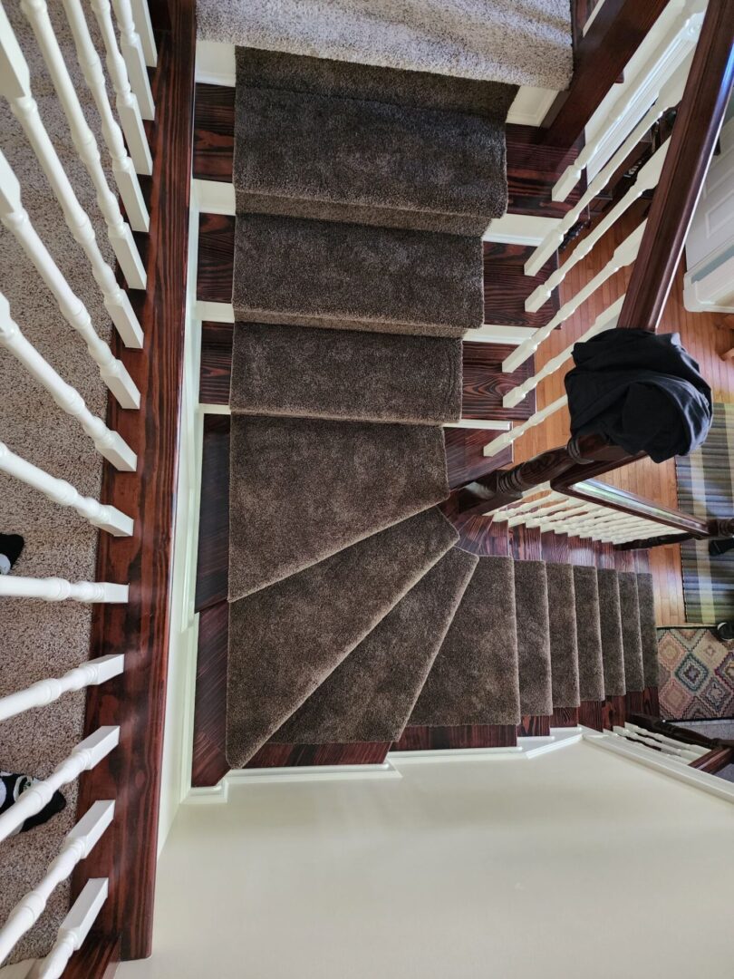 A staircase with brown carpet and wooden steps.