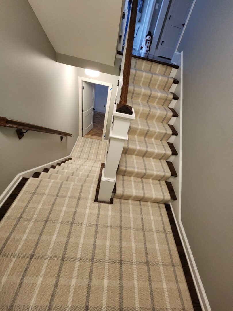 A staircase with a beige and brown checkered carpet.