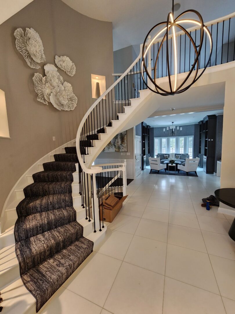A staircase with a black and white carpet on the bottom.